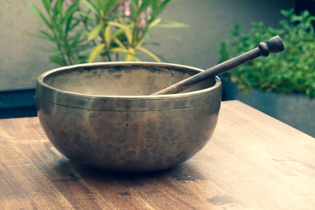 Bol chantant tibétain et son maillet sur une table en bois