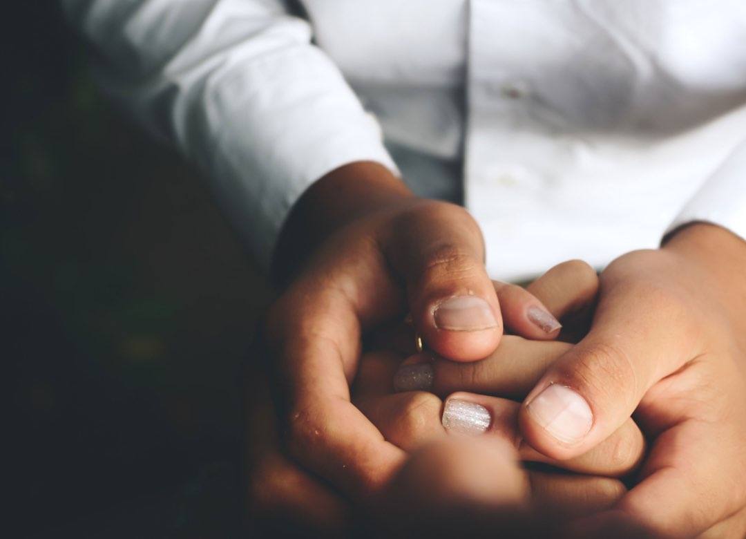 Mains tenant avec bienveillance les mains d’une autre personne
